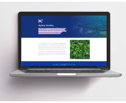 A imagem exibe um laptop aberto com uma página da web na tela. O cabeçalho azul escuro contém o logotipo 'B' e o texto 'Ações Verdes'. Abaixo, há um corpo de texto em português, e à direita, uma imagem de folhagem verde.