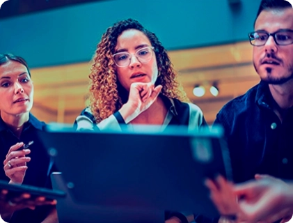 Tr¿s pessoas olhando para uma tela de computador