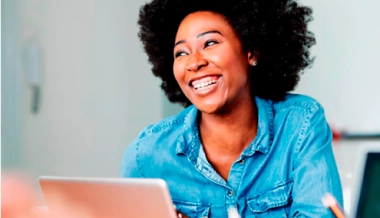 Mulher sorrindo em frente ao um notebook