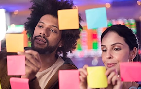 Two people sticking cards on a board